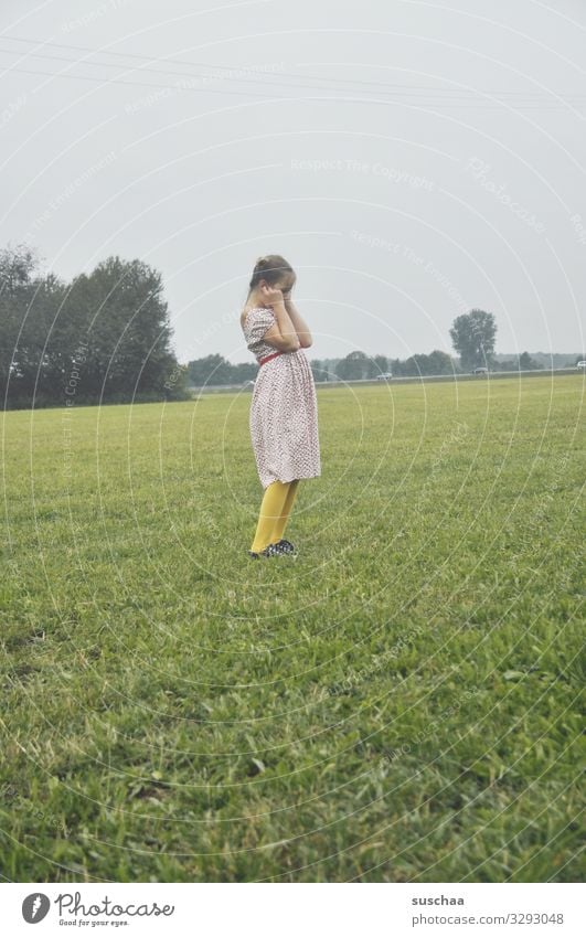 gräuschbelästigung Kind Mädchen Kindheit Außenaufnahme Wiese Natur Landschaft Spielen laut Geräusch Knall Luftballon Ohren zu halten