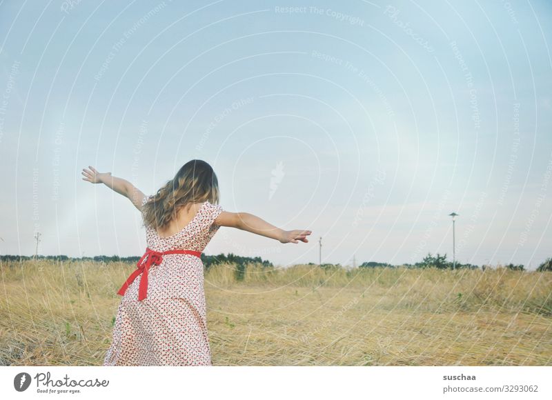 mädchen auf einem strohfeld spielt "fliegen" Kind Mädchen Kleid Außenaufnahme Natur Feld Getreidefeld Kornfeld Strohfeld Landschaft Sommer Wärme ausgestreckt