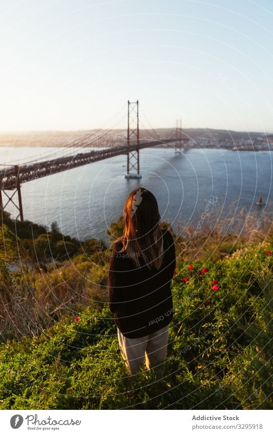 Nicht erkennbare weibliche Bewunderin der Brücke über den Fluss Frau bewundern Abend Suspension modern Himmel wolkenlos Portugal Wahrzeichen Architektur Gebäude