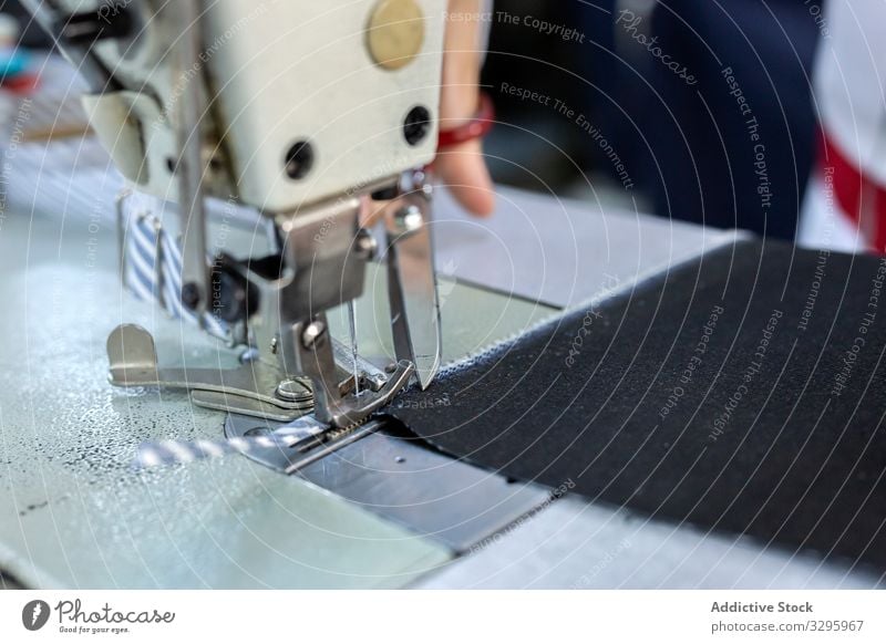 Frauenhände in einer Textilfabrik beim Nähen auf einer Industrienähmaschine. Fabrik Bekleidung Herstellung Arbeiter Maschine Hände Gewebe Hose Blue Jeans Beruf