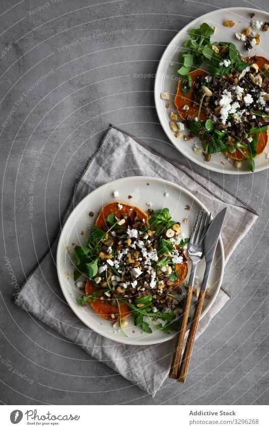 Köstlicher frischer Salat auf dem Tisch Salatbeilage Mittagessen Süßkartoffel gebacken Speise Silberwaren Teller Serviette Küche Gesundheit Lebensmittel