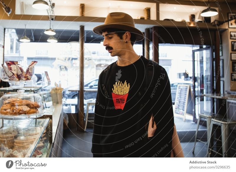 Hipster betrachtet Desserts im Schaufenster einer Bäckerei Mann Aussehen Sortiment Wahl Gebäck Frankreich Paris Anzeige sich[Akk] entspannen männlich Erholung