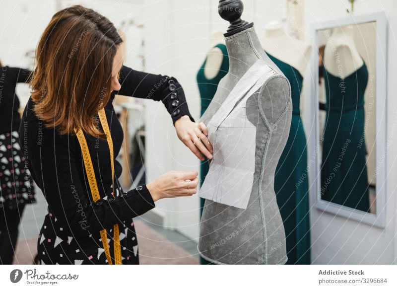 Schneiderin arbeitet mit Schaufensterpuppe im Atelier Damenschneiderin Werkstatt Frau befestigen Ausschnitt Stecknadel Bekleidung Designer Mode Beruf Handwerk