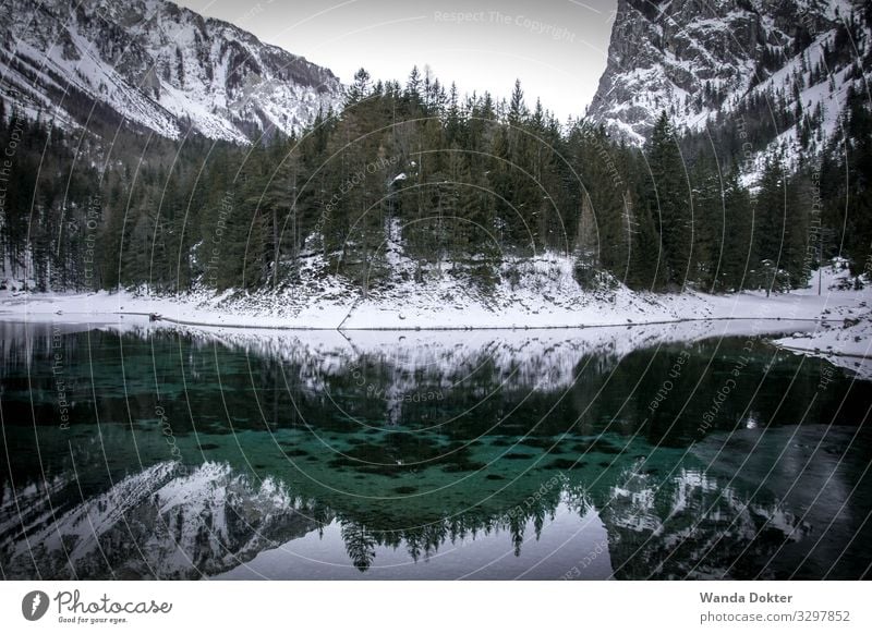 Mountain Landscape reflected in a small turquoise Lake in Winter Natur Landschaft Wasser Eis Frost Schnee Baum Felsen Alpen Berge u. Gebirge