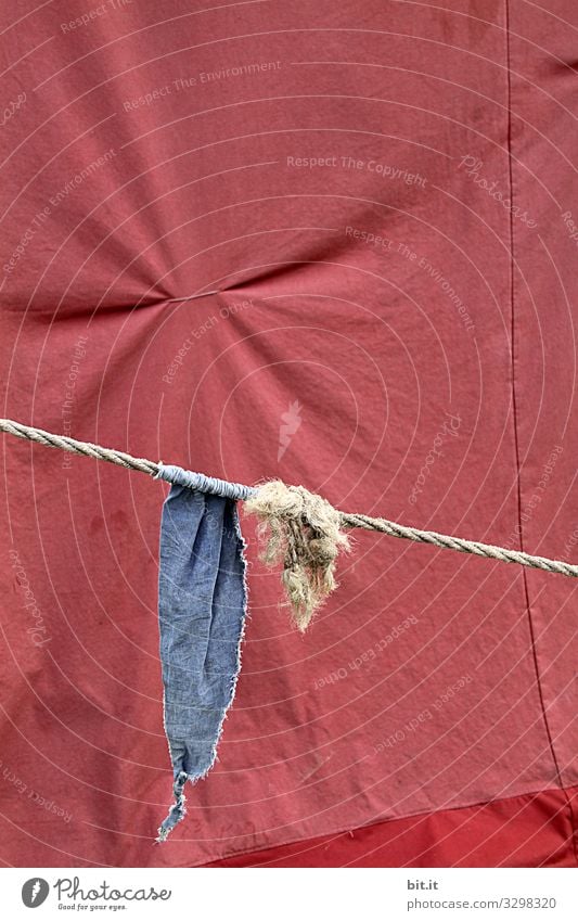 Blaue Fahne, Wimpel, Flagge hängt am Seil, Schnur mit Knoten, vor Zeltplane in Rot, mit zusammen gezogenem Stoff, zur Falte, bei einer Veranstaltung. Plane Band