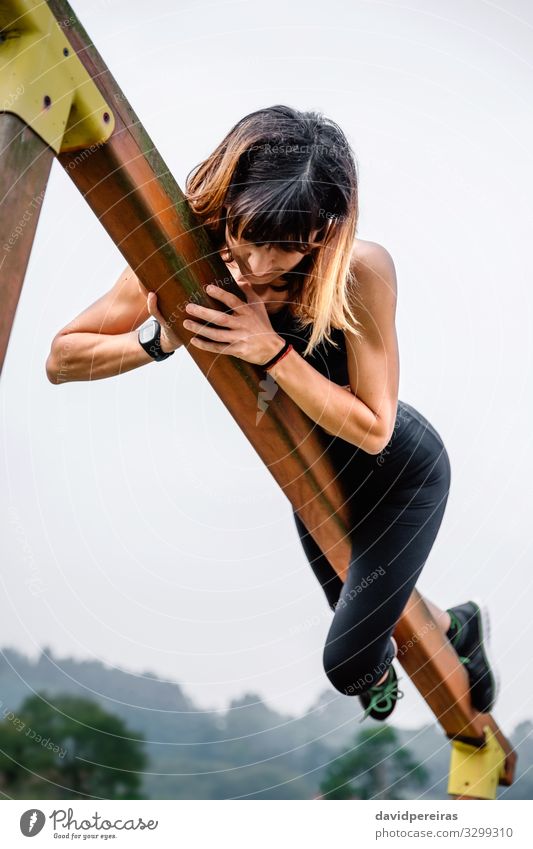 Sportlerin beim Training an eine Holzstange gepackt Lifestyle Körper Klettern Bergsteigen Mensch Frau Erwachsene Natur Park Fitness dünn muskulös stark Kraft