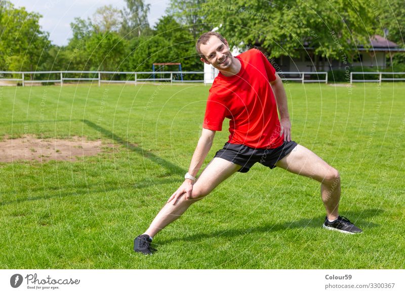 Dehnungsübung Lifestyle Wellness Freizeit & Hobby Sport Sportler Fußballplatz Mensch maskulin Junger Mann Jugendliche Natur Bewegung Fitness Blick