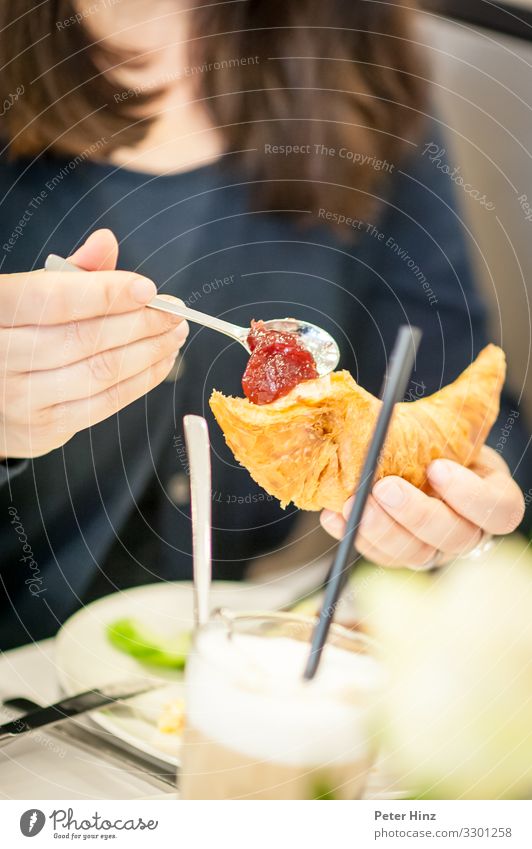 Frühstücken mit Croissant und Marmelade Teigwaren Backwaren Essen Kaffeetrinken Büffet Brunch Getränk Heißgetränk Latte Macchiato Teller Glas Trinkhalm Besteck