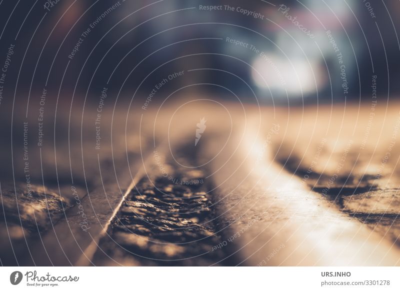 Straße mit Schienen in der Nacht und Autoscheinwerfer im Hintergrund Menschenleer Verkehrswege Straßenverkehr Gleise Straßenbahngleis bedrohlich dunkel blau