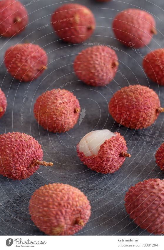 Frische Litschi-Früchte auf einem grauen Tisch Frucht Diät exotisch frisch saftig rosa Lychee roh offen Chinesisch asiatisch tropisch Fruchtfleisch süß lichi