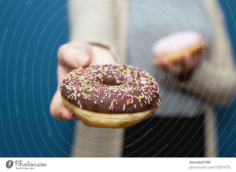 Frau hält einen köstlichen bunten Donut-Streusel in der Hand Dessert Frühstück Diät Haut Erwachsene Finger lecker gelb rosa schwarz weiß Krapfen süß Snack