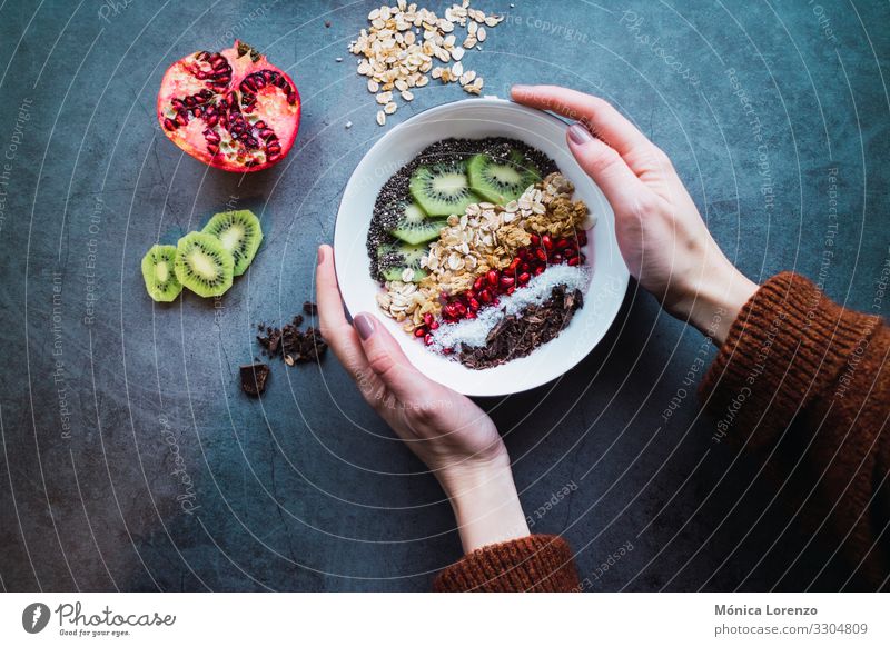 Frauenhände halten eine Smoothie-Schüssel mit veganen Zutaten. Joghurt Frucht Dessert Frühstück Vegetarische Ernährung Diät Schalen & Schüsseln Mensch