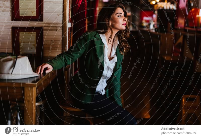 Charmante Dame in eleganter Kleidung im Cafe Frau stylisch Café Outfit modisch trendy jung lässig Model anhaben Lächeln genießen charmant Zubehör schick