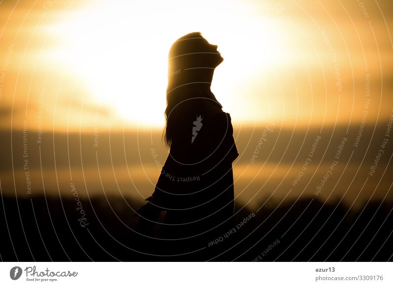 Jugend Frau Seele auf orange Sonne Meditation in Erwartung der zukünftigen Zeiten. Silhouette vor Sonnenuntergang oder Sonnenaufgang in sommerlicher Natur. Symbol für Heilung Burnout Therapie, Wellness Entspannung oder Auferstehung.