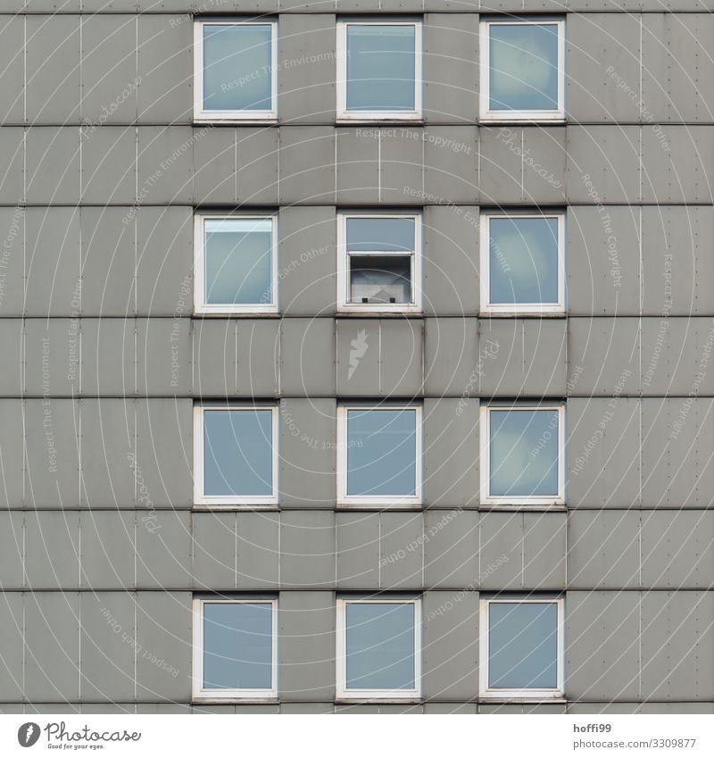 trostlose Hochhausfassade mit einem halb geöffneten Fenster Haus Gebäude Fassade Stein Glas Linie Armut bedrohlich kalt kaputt modern retro Stadt blau grau