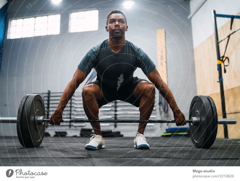 Crossfit-Sportler, der mit einer Langhantel trainiert. Lifestyle Körper Mann Erwachsene Fitness sportlich muskulös stark schwarz Kraft Konzentration Curl-Hantel