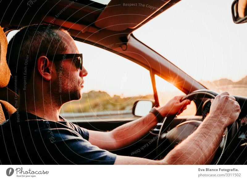 junger Mann am Steuer und am Steuer bei Sonnenuntergang. reisekonzept fahren PKW Straße Ferien & Urlaub & Reisen Ausflug Kaukasier Jugendliche Fahrer reisend