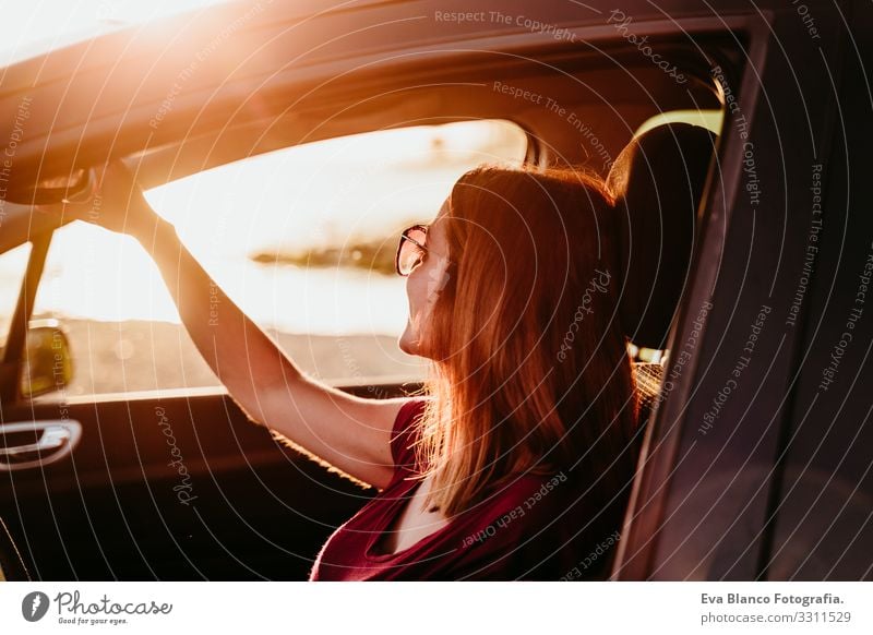 junge Frau, die bei Sonnenuntergang Auto fährt. reisekonzept Jugendliche PKW fahren Strand Fahrer Ferien & Urlaub & Reisen reisend Ausflug Lifestyle Kaukasier