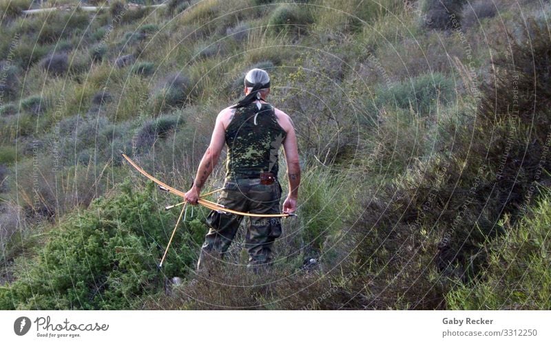 Auf der Jagd in der Wildnis Mensch maskulin Mann Erwachsene 1 45-60 Jahre Kämpfer Landschaft Gras Sträucher Berge u. Gebirge Tattoo Stirnband langhaarig Zopf