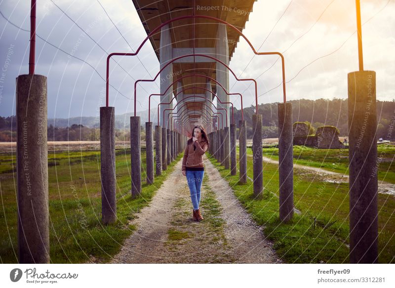 Junge Frau beim Wandern auf dem Land, unter einer Brücke Winter Mensch feminin Jugendliche Erwachsene 1 18-30 Jahre Landschaft Gebäude Architektur Beton Schutz