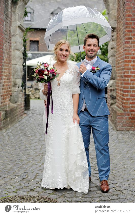 Hochzeitspaar im Regen standesamt Braut Gebäude Mauer just married Glück Fliege Anzug Blumenstrauß Brautstrauß Paar Beautyfotografie Ehemann Junger Mann