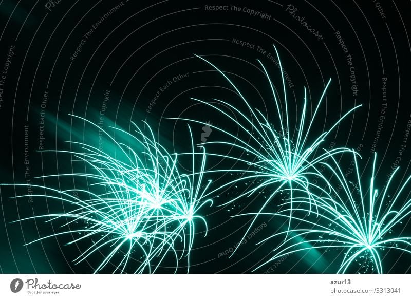 Am Himmel des Luxus-Feuerwerks-Ereignisses sind schöne, feine, türkisfarbene Sterne zu sehen. Unterhaltungs-Sternfeuerwerk mit schwarzem, dunklem Nachthintergrund.