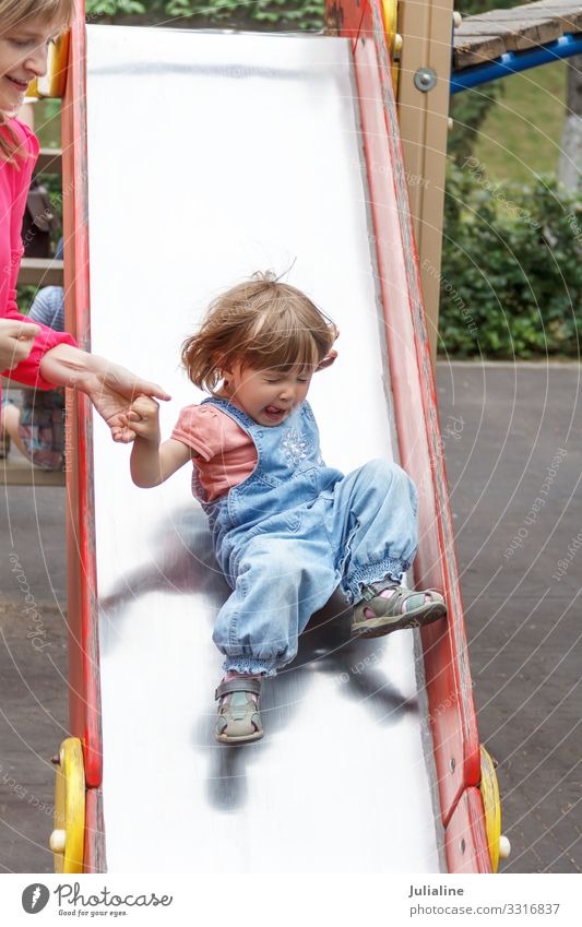 Mädchen, das mit zerzaustem Haar auf Hütten reitet Lifestyle Freizeit & Hobby Spielen Sommer Kind Baby Frau Erwachsene Kindheit Park blond weiß Vorschulkind