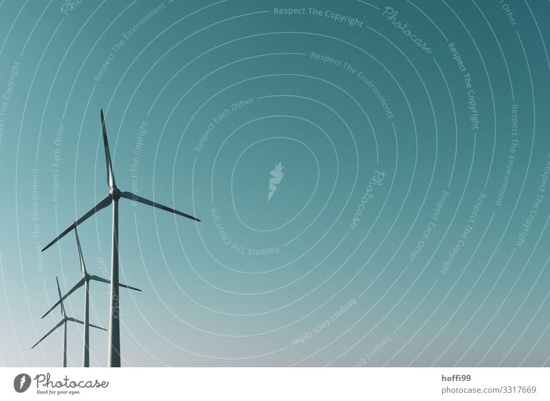 drei gestaffelte Windräder vor winterlich blau türkis farbigem Himmel Technik & Technologie Windkraftanlage Wolkenloser Himmel Sonne Sonnenlicht Schönes Wetter