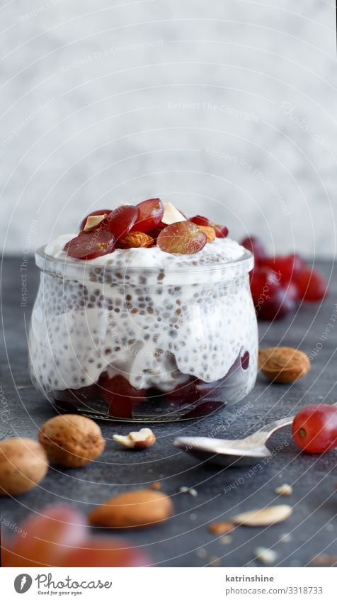 Chia-Puddingparfait mit roten Trauben und Mandeln Joghurt Frucht Dessert Essen Frühstück Diät Löffel dunkel grau weiß Glas Parfait Weintrauben rote Weintrauben