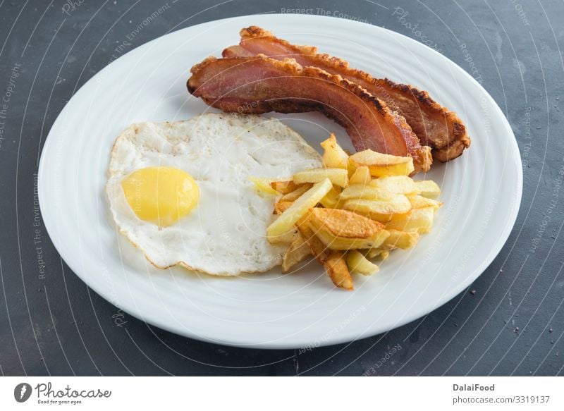 Scheibe Speck, Ei und Kartoffelchips Frühstück Teller Diät schwarzer Hintergrund Chips Lebensmittel Kartoffeln Spanien Spanisch torrezno torreznos Farbfoto