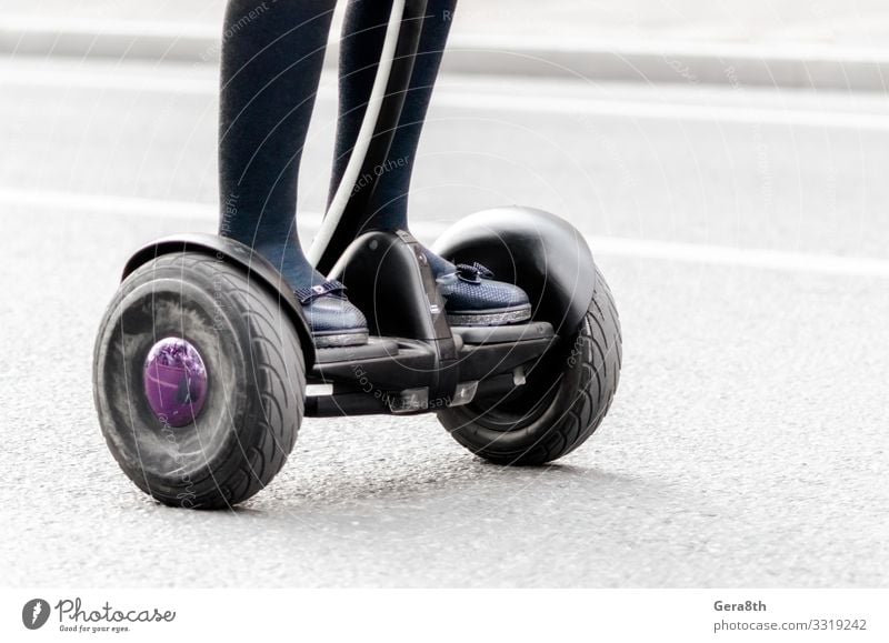 weibliche Beine auf einem Elektroroller auf einer Stadtstraße aus nächster Nähe Frau Erwachsene Verkehr Straße Bekleidung Schuhe gebrauchen Großstadt elektrisch