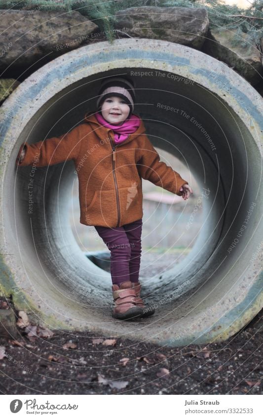 Kind im Tunnel Spielplatz feminin Kleinkind 1 Mensch 3-8 Jahre Kindheit Winter Park Jacke wollwalk Wolljacke Schal Mütze Bewegung Lächeln Spielen toben frech