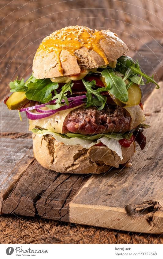 Cheeseburger Fleisch Käse Gemüse Brot Brötchen Mittagessen Tisch Holz dunkel frisch lecker hamburger rustikal Speck geröstet brioche Brennpunkt selektiv