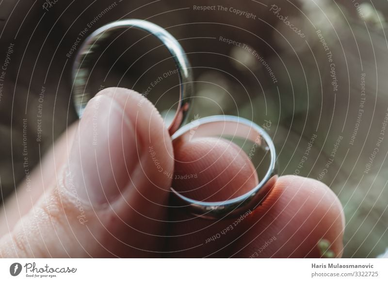 Trauringe in der Hand halten Makro in Nahaufnahme auf verschwommenem Hintergrund Hochzeit Schmuck Ring gold träumen schön Zusammensein Liebe Farbfoto