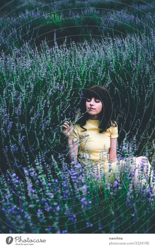 Junge brünette Frau sitzt umgeben von Lavendel jung hübsch retro altehrwürdig Natur natürlich wirklich offen sich[Akk] entspannen Ruhe Szene Blumen Frühling