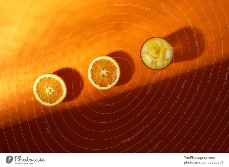 Kaltes Orangensaftglas und im Sonnenlicht halbierte Orangen Frucht Frühstück Getränk Erfrischungsgetränk Glas obere Ansicht Zitrusfrüchte farbenfroh halbieren