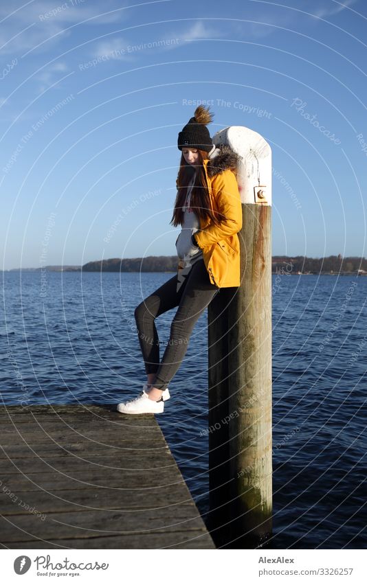 Junge Frau auf einem Steg lehnt an einem Pfahl Lifestyle schön harmonisch Ausflug Jugendliche 18-30 Jahre Erwachsene Landschaft Wasser Herbst Schönes Wetter