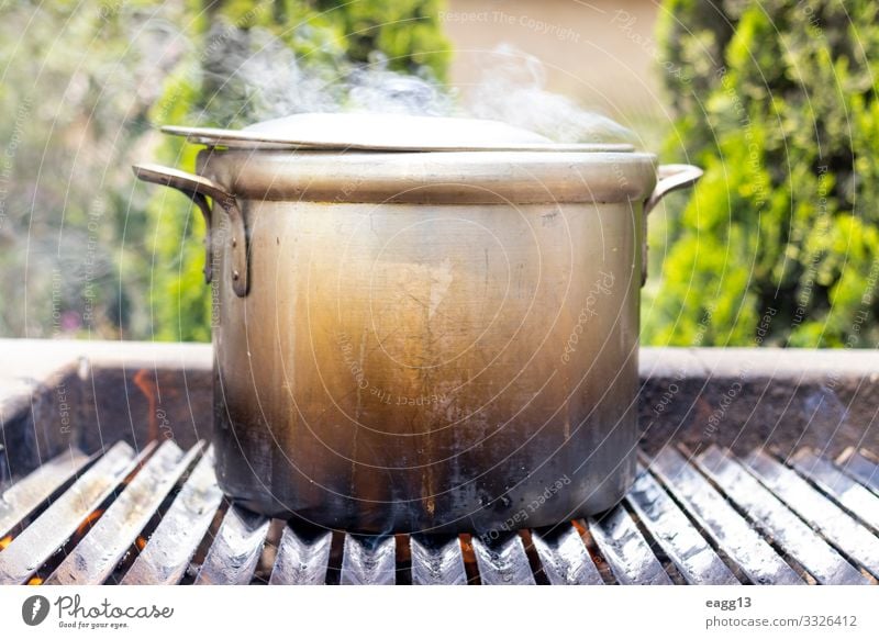 Zubereitung von Suppe in einem Topf, in der Natur. Fleisch Eintopf Ferien & Urlaub & Reisen Camping Küche Wärme Wald Wohnmobil Metall groß heiß Tradition