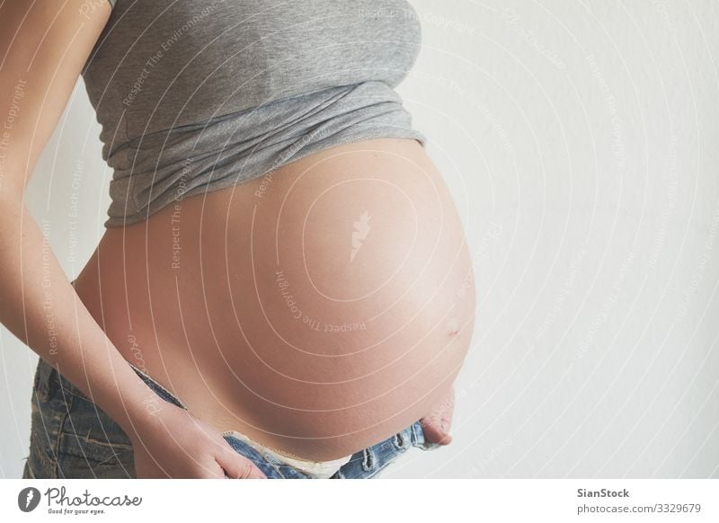 Schwangere Frau versucht, ihre Jeans zu tragen Lifestyle Glück schön Körper Leben Mensch Baby Erwachsene Mutter Hand berühren Liebe sitzen schwanger weiß