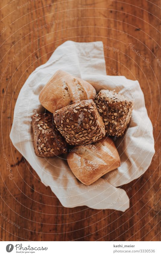 Semmeln in Korb Lebensmittel Getreide Teigwaren Backwaren Brötchen Ernährung Frühstück Abendessen Bioprodukte Tischwäsche kaufen Holz Gesundheit nachhaltig