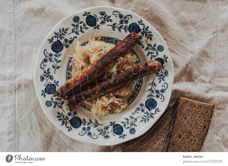 Zwei mit Kraut Wurstwaren Sauerkraut Brot Bratwurst Ernährung Abendessen Geschirr Teller retro rund blau gefräßig Hausmannskost altehrwürdig Essen zubereiten