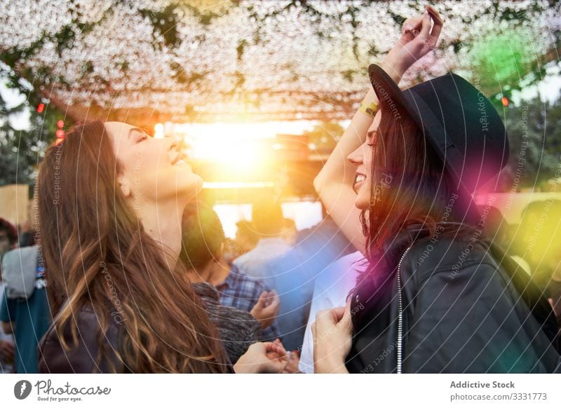 Angenehme Frauen tanzen und haben Spaß bei einer Party im Park Tanzen Stadtfest Erhöhung Handerheben Zwei Personen Leder Jacke Feier Menschengruppe Spaß haben