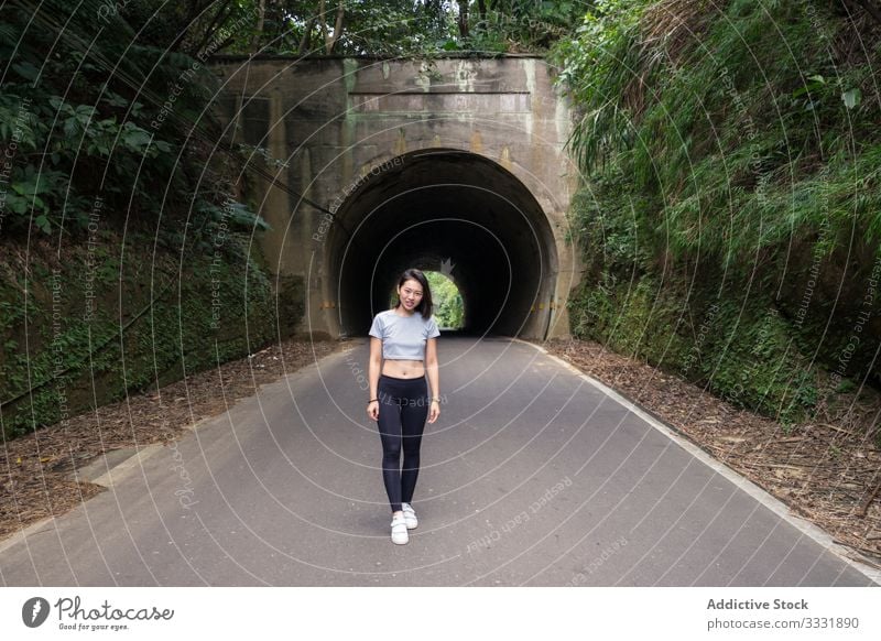 Zufriedene Reisende beim Spaziergang auf dem Land reisen laufen Landschaft Stollen sportlich Pflanzen grün Frau asiatisch jung Lächeln Lachen genießen