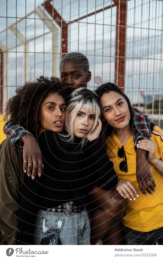 Diverse Gruppe von lächelnden Frauen, die sich auf dem Rasen umarmen Freund umarmend Menschengruppe Lächeln Lachen Kuscheln lässig Spaß Zusammensein jung