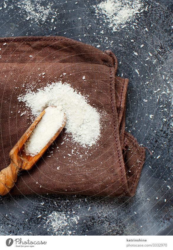 Kokosnussmehl in einem Holzlöffel aus nächster Nähe Gemüse Frucht Ernährung Vegetarische Ernährung Löffel dunkel oben braun grau weiß Schuppen Mehl Keton