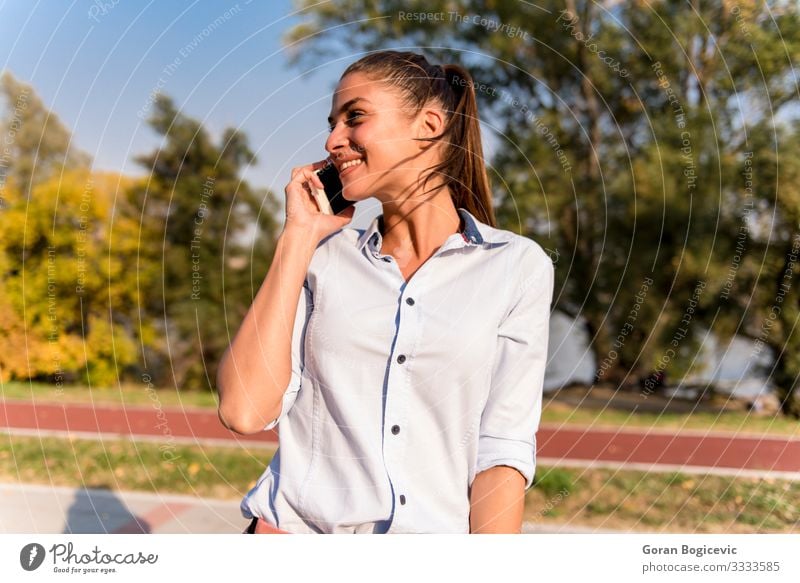 Junge Frau mit Mobiltelefon im Park am Fluss Stil Glück Erholung Freizeit & Hobby Sommer Telefon PDA Technik & Technologie Internet Mensch Jugendliche