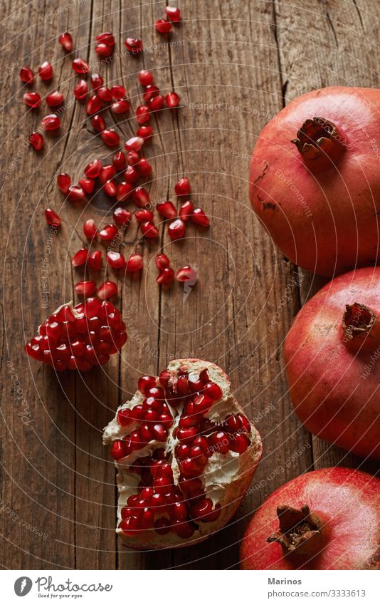 reife Granatapfelfrüchte auf Holztisch. Frucht Dessert Vegetarische Ernährung Diät Saft Garten Tisch frisch natürlich saftig rot Farbe Gesundheit Vitamin