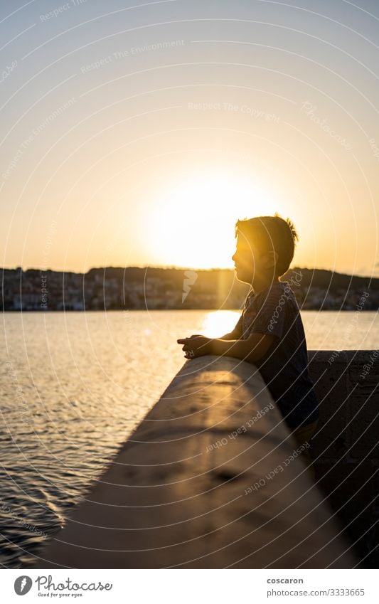 Ein süßes Kind, das einen erstaunlichen Sonnenuntergang in Argostoli, Griechenland, erlebt. Lifestyle Freude Glück schön Gesicht Freizeit & Hobby