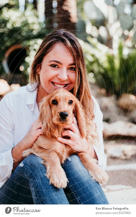 junge Frau und ihr süßer Cockerspaniel-Welpe im Freien Hund Haustier Park Sonnenstrahlen Außenaufnahme Liebe Umarmen Lächeln Rückansicht Küssen züchten