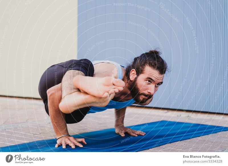 mann in der stadt, der yoga-sport betreibt. blauer hintergrund. gesunde lebensweise Yoga Mann Sport Gesundheit Außenaufnahme Großstadt Blauer Hintergrund